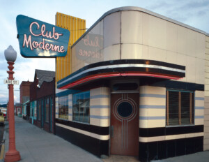 Art moderne building on street corner with flat roof, rounded corners, and smooth walls.