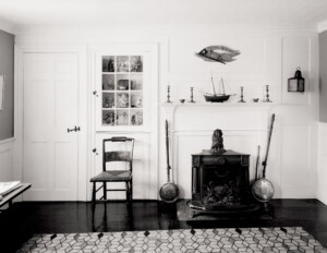 Whitewashed interior featuring cape cod door mouldings accompanied with cabinetry mouldings and decorations on a right justified mantle.