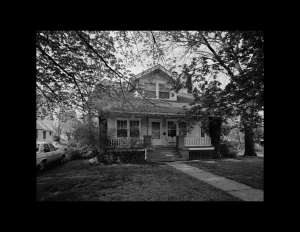 Bungalow style house that has a dormer on the roof, has a full front porch, with stone stairs going to the front door.