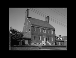 Chesapeake colonial style house with steep roof, two wide chimneys, exterior cornice, and staircase to the front door.