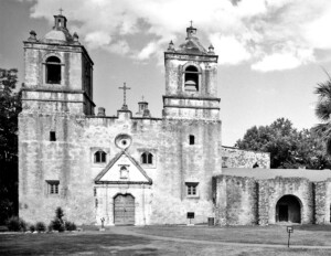 Spanish colonial style building with two side towers, door mouldings, window mouldings, and is made out of stucco-clad.