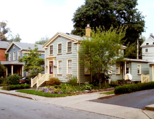 Greek revival style house featuring steps leading to the doorway accompanied with railing, doorway moulding, and an exterior cornice.