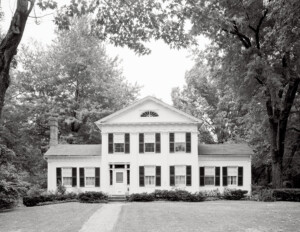 Greek Revival Western Reserve style building with door mouldings, and double hanging windows with shutters.