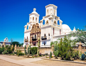 Spanish colonial style building that has balconies, two towers, and is made out of stucco-clad.