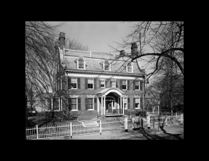 Colonial revival style exterior with curved balustrade and columned porticos, curved roof with railings, and double-hung windows with shutters.