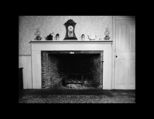 Farmhouse style fireplace featuring fireplace mouldings, and door mouldings.