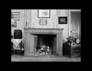 French colonial style house room featuring door mouldings, fireplace mouldings, and hanging picture frames.