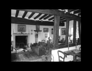 Interior of french country style house featuring exposed wooden ceiling beams, fireplace mouldings, and window mouldings.