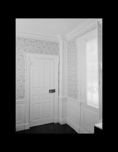 Interior of greek revival style house featuring door mouldings, columns, interior cornice and wall mouldings.