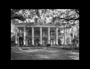 Greek revival southern plantation style featuring window mouldings with shutters, exterior cornice, door mouldings, and chimney.