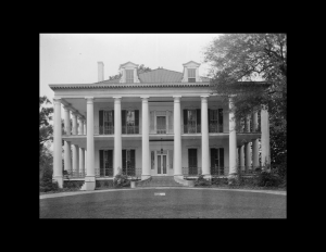 Greek revival southern plantation style featuring shingle siding, window mouldings, and door mouldings.