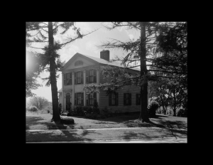 Greek Revival Western Reserve style building featuring double hanging windows with shutters, and an all brick chimney.