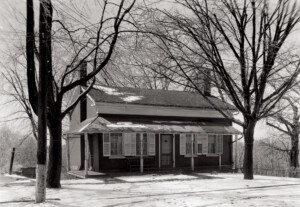 Birthplace of Thomas Edison house with covered front porch, door mouldings, window mouldings with shutters, and overhanging roof.