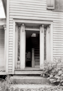 Front door of the Blackman house featuring steps to entrance, beautiful door mouldings, and window casing along the side of the door.