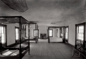 Interior of Columbian House bedroom showing off hardwood floors, brick fireplace, and window casing mouldings.