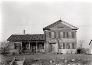 Exterior of Dirlam Allen House featuring covered porch with columns, windows casings with shutters, and door mouldings with panel molds.