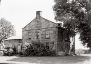 Exterior of Herrick House showcasing brick walls, covered steps to entrance, and door mouldings featuring panel molds, and column detail.