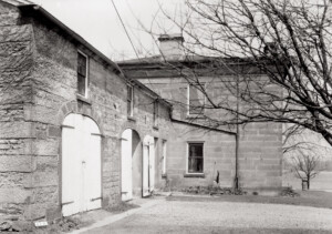 Exterior of Hurst House showcasing all brick walls, window mouldings, and oval wooden doors.