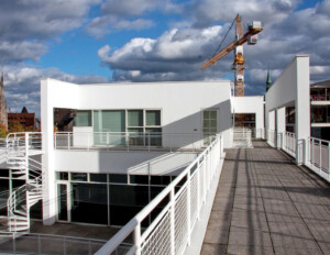 White international style building that is mainly outside featuring a winding staircase to second story, railings, and window and door mouldings.