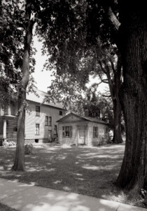 Exterior of Joshua R Giddings law office featuring shingle siding, door mouldings with panel molds, and windows with shutters.