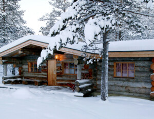 Log Cabin Style house in winter, traditional logs, hangover roof, and window mouldings.