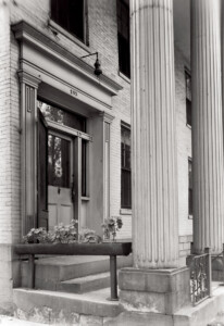 Exterior of Moore Brewster House pillar featuring front door with door casing, panel molds, window casing, and column detail.