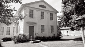 Exterior of Lew Lawyer House with cornice mouldings, and door casing with panel molds, and column detail.