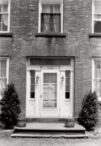 Exterior of Thomas Hurst House featuring front door with column detail, and panel molds and steps to entrance door