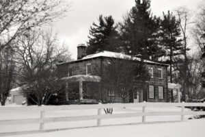 Exterior of Wolcott House front of building featuring pillars, chimney on the roof and windows with shutters