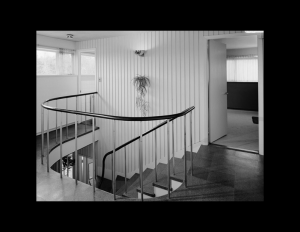 Interior of an international style house that has wrap around stair railings, door mouldings and window mouldings.