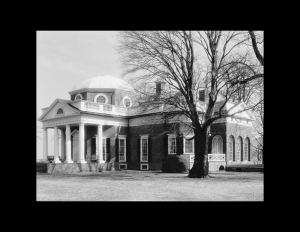 Neoclassical building with railings on roof, cornice mouldings, door mouldings, and tall window mouldings accompanied with porthole windows.