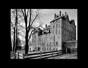 Arts and crafts style building that is very tall, has many windows and is triangular in shape.