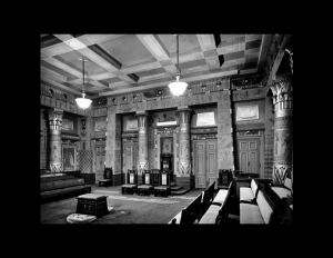 Interior of an egyptian revival style building showcasing two columns, interior cornice, wall mouldings, and door mouldings.