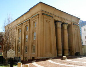 Egyptian revival style buildings showcasing angular structure, beautiful window mouldings, and two giant columns where the entrance is located.