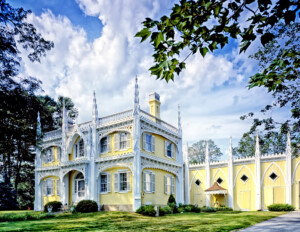 Gothic revival style house with pointed arches with mouldings, windows with shutters, and ornate decoration.