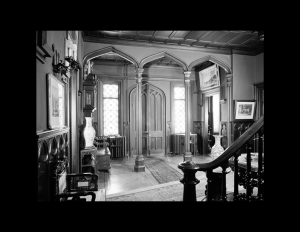 Interior of gothic revival style entrance room column mouldings, ceiling panel mouldings, door mouldings, and staircase baluster.