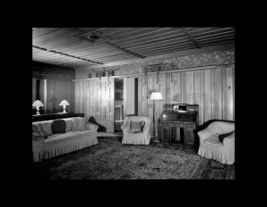 Interior of shingle style building with ceiling mouldings and wall mouldings.