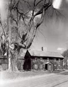 Exterior of Benjamin Abbott Farmhouse featuring shingle roofing, door mouldings, and window casing mouldings.