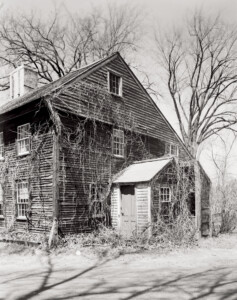 Exterior of Benjamin Abbott Farmhouse side of house featuring shingle roofing, door mouldings, and window casing mouldings.