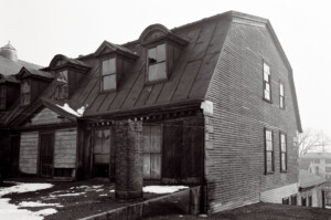 Exterior of BENJAMIN PICKMAN HOUSE featuring shingle siding, gable dormers, slanted roof, and window casing mouldings.