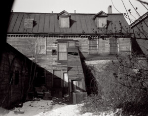 Rear side exterior of BENJAMIN PICKMAN HOUSE featuring shingle siding, gable dormers, slanted roof, and window casing mouldings.