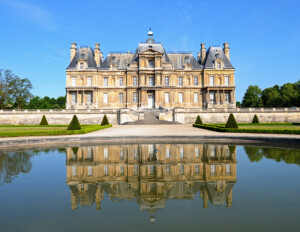 Louis XIV style mansion featuring beautiful steps to entrance, column detail, gable dormers on roof, and window casing mouldings.