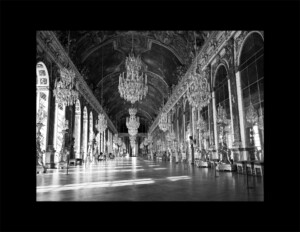 Interior of Louis XIV style building featuring large chandeliers, curved ceiling, and huge window casing mouldings.