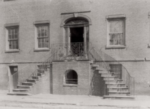 Photo from the south entrance with split stairway to front door. Beautiful exterior mouldings into the entranceway with iron fencing.