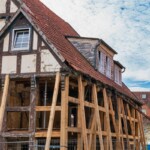 A historic tudor style home is undergoing significant structural restoration after years of neglect